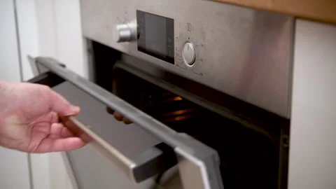 Cooking timer and oven settings being checked in a modern kitchen Video stock 310844384