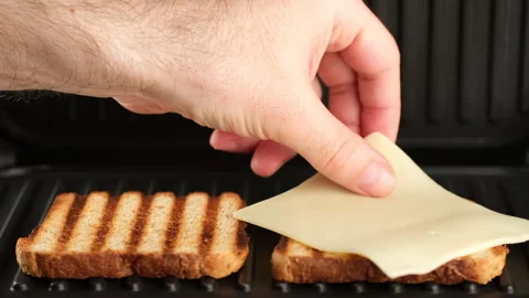 Cooking toast bread with cheese on grill. Sandwich with cheese 스톡 동영상 242587453