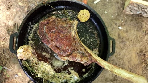 Cooking Tomahawk Steak Over Campfire in Cast Iron Stock-Footage 280064024