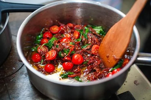 Cooking tomato sauce with tomato and basil by chef Stock Photos