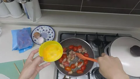 Cooking Tomatoes, Bacon, and Eggs in a Frying Pan with a Spatula Stock Footage 343148457