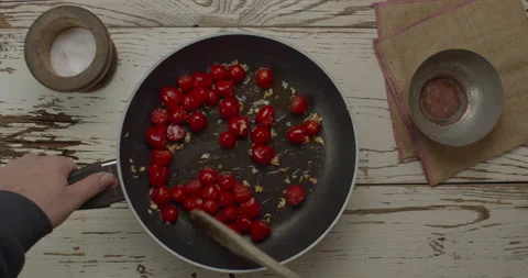 Cooking tomatoes with fried garlic on a cooking pan Stock Footage 148317260