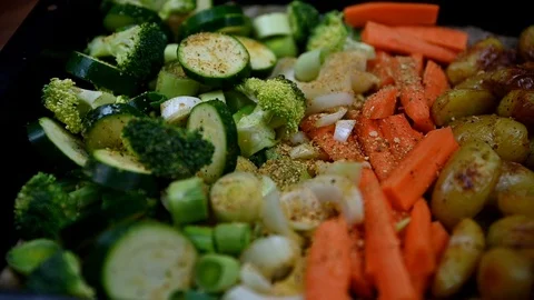 Cooking tray full of green vegetables carrots, patatos, sprinkled with garlic Video stock 125832029