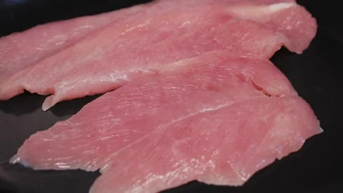 Cooking turkey breast on pan close-up. Preparing healthy dinner at home. Stock Footage 313149103
