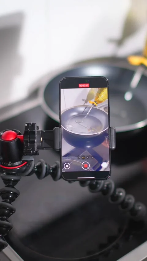 Cooking tutorial setup with smartphone and pan on stove in modern kitchen Stock Footage 320304169
