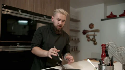 Cooking TV show celebrity host cooking a dish, talking into camera Stock Footage 158928198