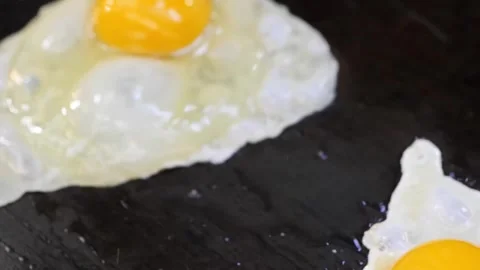 Cooking Two Sunny-Side-Up Fried Eggs in a Hot Frying Pan, Close-Up Stock Footage 331956435