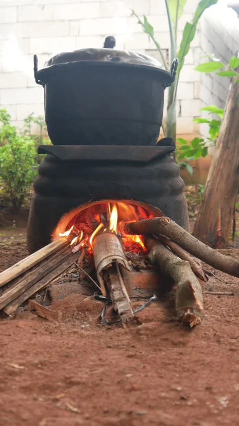 Cooking using a traditional stove that uses firewood as fuel Stock Footage 309056530