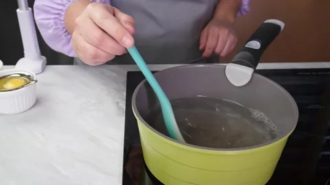 Cooking utensil stirring in a modern kitchen setting with boiling water. step 4 Video stock 292007407