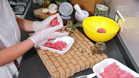 Cooking utensils on trendy kitchen surface, woman in gloves rotating seasoned Stock Footage 225864079
