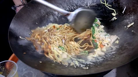 Cooking vegetable fried noodles while stirring and adding egg Stock Footage 272298073