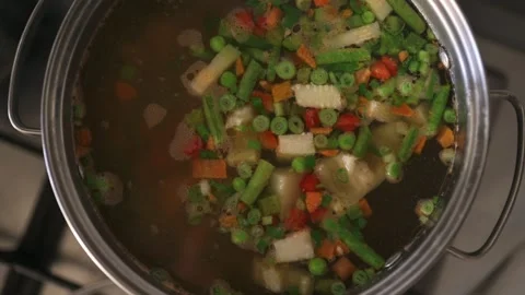 Cooking vegetable soup with many frash ingredients left to boil on the hob Stock Footage 303625504