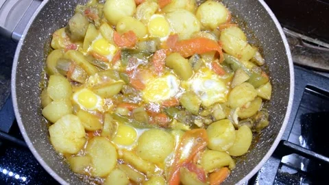 Cooking vegetable stew in a frying pan in a home kitchen Stock Footage 293976409