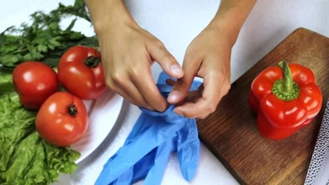 Before cooking vegetables chef puts on rubber gloves on both hands. Stock Footage 82236979