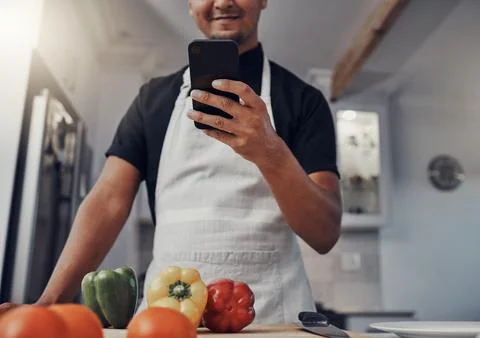 Cooking vegetables, phone and man in kitchen while online with house wifi Stock Photos
