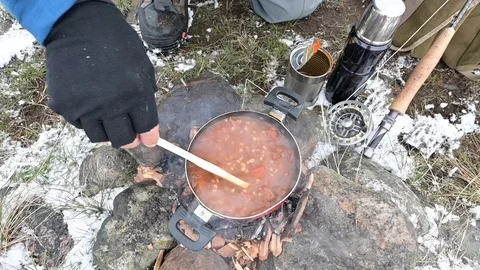 Cooking on a wood fire by a river Stock Footage 120519103