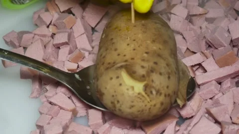 The cook's hand checks with a toothpick a boiled potato in a peel over a boi Vídeos de archivo 230120380