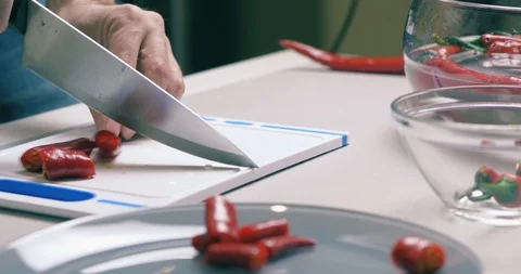 The Cook's Hand Cuts Hot Red Fresh Chili Pepper It On A Cutting Board Stock Footage 128096360