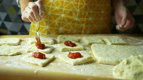 Cook's hand puts jam into donuts. Making homemade donuts with jam Stock Footage 220445981