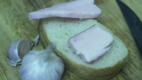 The cook's hand puts two fresh pieces of lard on bread, close-up Vídeos de archivo 221991288