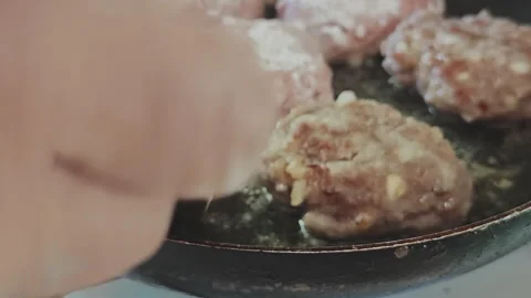 Cook's hand is seen using a wooden spatula to flip sizzling minced pork Stock Footage 345971500