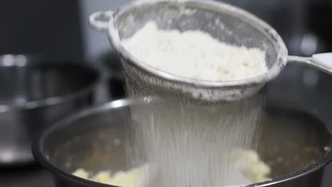 The cook's hand sifts flour through a sieve into a bowl with dough, baking, side Stock Footage 164657932