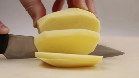 The cook's hands are cut into slices with a knife for frying potatoes. Stock Footage 259981673