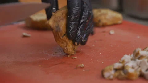 Cooks' hands cut the baked meat into pieces in slow motion Stock Footage 99818331