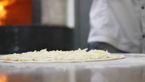 Cook's hands in the kitchen putting the ingredients on the pizza. Pizza concept Stock Footage 77349988