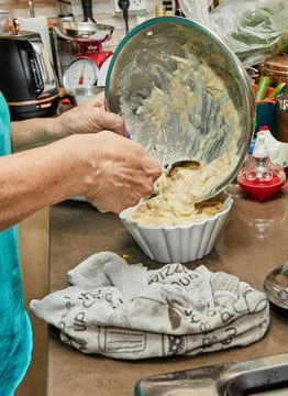 Cook's Hands Pouring Stuffing Mixture into Dishes for Cooking Preparation Stock Photos