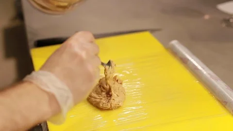Cook's hands preparing ice cream with peanut cream on board in kitchen Stock Footage 111072337