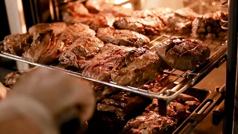 Cook's hands preparing meat steaks on baking tray in oven Stock Footage 111072130