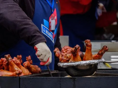 Cook's hands in the process of preparing bird legs. On the cook's apron, the  Stock Photos