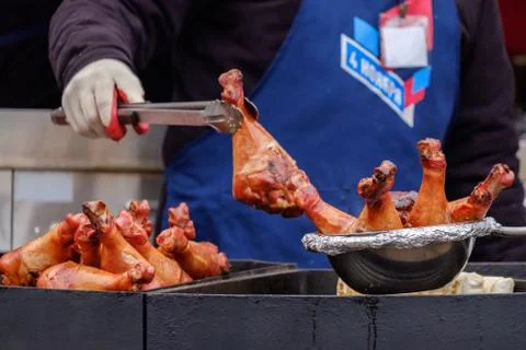 Cook's hands in the process of preparing bird legs. On the cook's apron, the  Stock Photos