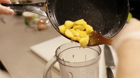 Cook's hands put fried apples in a blender Stock Footage 111072383