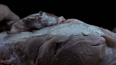 The cook's hands turn the raw piece of meat. Stock Footage 166160987