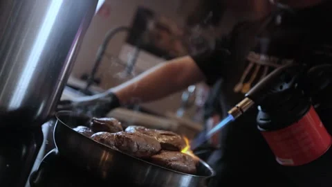 Cooks the meat with a burner Stock Footage 300028224