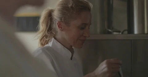 Cooks talking in kitchen during meal preparation Stock Footage 76413399