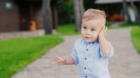 Cool 1 year old kid plays with the keys to the car. Speaks as on the phone as a Stock Footage 80017067