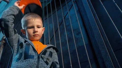A cool 5 year old boy takes off and puts on his cap while standing in a Stock Footage 89133590
