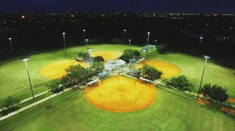 Cool Aerial shot flying over baseball parks in the evening during game Stock Footage 68996569