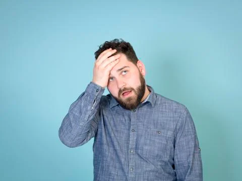 Cool and young man posing in front of blue background with copy space Stock Photos