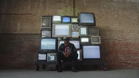 Cool Artist Sits In Front Of Static Televisions Stock Footage 270329455
