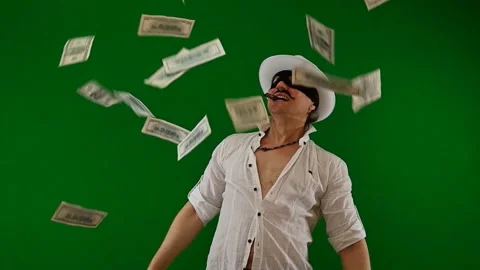 Cool bad guy with a black mask, white hat, cigar and money on a green backdrop Stock Footage 141856321