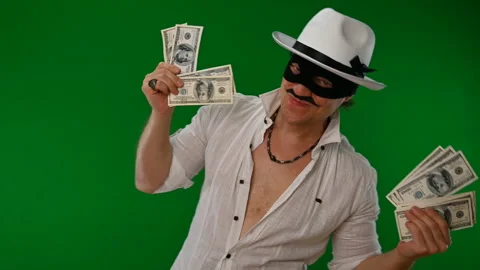 Cool bad guy with a black mask, white hat, cigar and money on a green backdrop Stock Footage 141856358