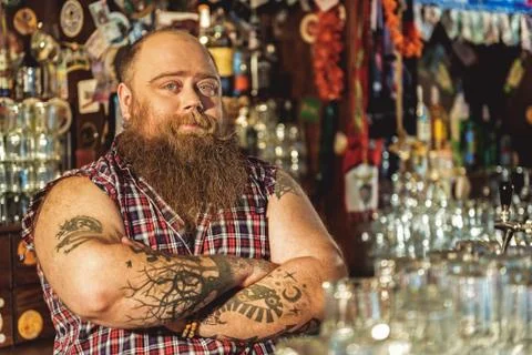 Cool bearded bartender situating in tap-room Stock-Fotos
