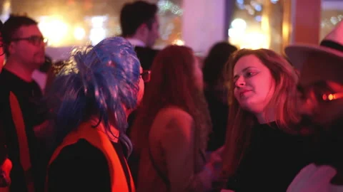 Cool bearded guy in glasses and blue haired wig dances in crowd of party people. Stock Footage 165322516