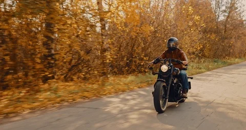 Cool biker rides on the highway in the fall. Motorcyclist walk in a helmet. Stock-Footage 118091514