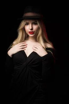 Cool blonde model with red lips posing over a dark background Stock Photos