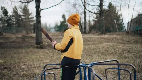 Cool boy rides a small carousel with a baseball bat. Cool funny teen 動画素材 126732014